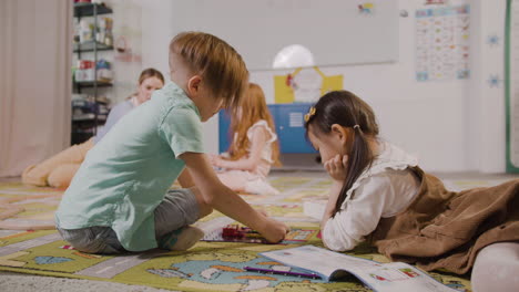 Kleines-Mädchen-Und-Kleiner-Junge-Spielen-Mit-Verschiedenen-Stücken-Auf-Dem-Teppich-Im-Klassenzimmer-In-Einer-Montessori-Schule-1