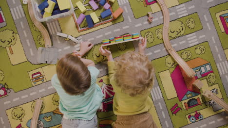 Top-View-Of-Children-Playing-With-Wooden-Pieces-Lying-On-A-Carpet-In-A-Montessori-School-Class-1