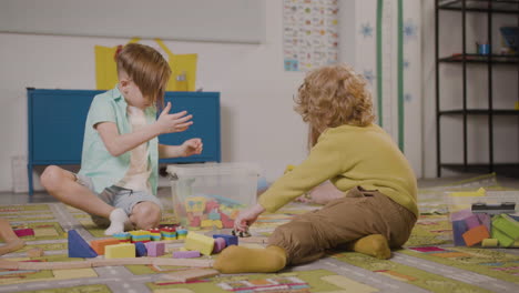 Junge-Sitzt-Auf-Einem-Teppich-In-Einer-Montessori-Schulklasse