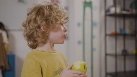 Niño-Comiendo-Una-Manzana-En-El-Aula-En-Una-Escuela-Montessori-1