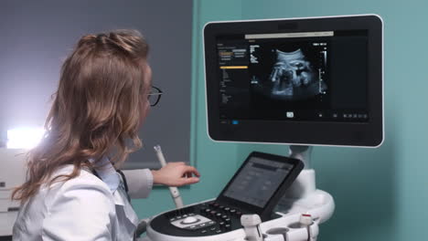 Female-Gynecologist-Showing-Image-Of-Fetus-On-Screen-Of-Ultrasound-Machine