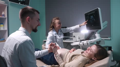 Schwangere-Frau-Mit-Ultraschall-Im-Gynäkologenbüro,-Während-Ihr-Liebevoller-Ehemann-Ihre-Hand-Hält-10