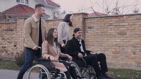Woman-And-Man-Taking-A-Walk-With-Her-Disable-Friends-In-Wheelchair-Around-The-City-1