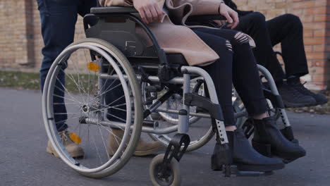 Camera-Focuses-On-Wheels-Of-A-Wheelchair-Spinning-On-A-Walk-In-The-Street