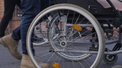 Camera-Focuses-On-Wheel-Of-A-Wheelchair-Spinning-On-A-Walk-In-The-Street
