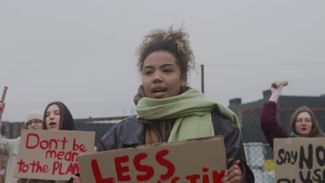 Junge-Amerikanische-Aktivistin,-Die-Während-Eines-Protestes-Gegen-Den-Klimawandel-Ein-Plakat-Aus-Pappe-Gegen-Die-Verwendung-Von-Kunststoffen-Hält
