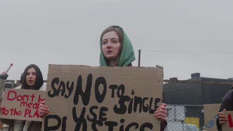 Young-Girl-Holding-A-Cardboard-Placard-Against-The-Use-Of-Plastics-During-A-Climate-Change-Protest