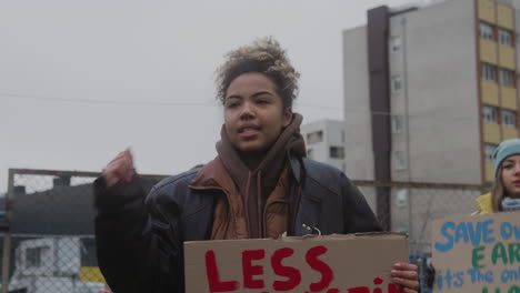 Junge-Amerikanische-Aktivistin-Hält-Ein-Plakat-Aus-Pappe-Gegen-Die-Verwendung-Von-Kunststoffen-Und-Protestiert,-Um-Die-Erde-Während-Eines-Protestes-Gegen-Den-Klimawandel-Zu-Retten