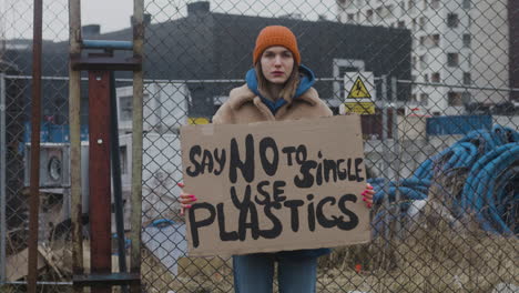 Junge-Aktivistin,-Die-Während-Eines-Protestes-Gegen-Den-Klimawandel-Ein-Plakat-Aus-Pappe-Hält,-Während-Sie-In-Die-Kamera-Blickt-3