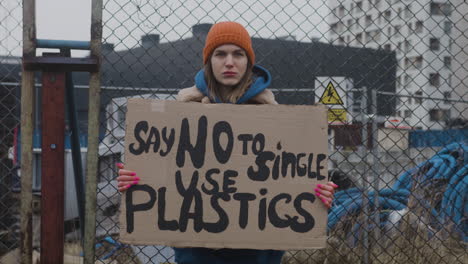 Junge-Aktivistin,-Die-Während-Eines-Protestes-Gegen-Den-Klimawandel-Ein-Plakat-Aus-Pappe-Hält,-Während-Sie-In-Die-Kamera-Blickt-4