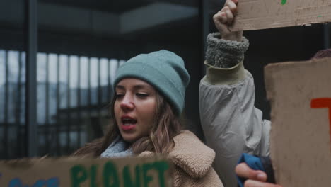 Nahaufnahme-Einer-Jungen-Aktivistin,-Die-Während-Eines-Protestes-Gegen-Den-Klimawandel,-Umgeben-Von-Anderen-Aktivisten,-Ein-Pappplakat-Hält