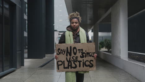 Junger-Amerikanischer-Klimaaktivist-Hält-Ein-Plakat-Und-Protestiert-Gegen-Die-Einwegkunststoffe,-Während-Er-In-Die-Kamera-2-Schaut