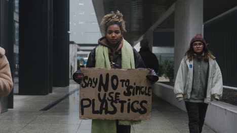 Junger-Amerikanischer-Klimaaktivist-Hält-Ein-Plakat-Und-Protestiert-Gegen-Die-Einwegkunststoffe,-Während-Er-In-Die-Kamera-3-Schaut