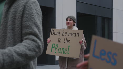 Young-Female-Activist-Holding-A-Cardboard-Placard-And-Protesting-Against-Climate-Change