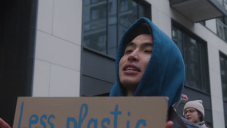 Nahaufnahme-Eines-Jungen-Männlichen-Aktivisten,-Der-Während-Eines-Protestes-Gegen-Den-Klimawandel-Ein-Plakat-Aus-Pappe-Gegen-Die-Verwendung-Von-Plastik-Hält-1