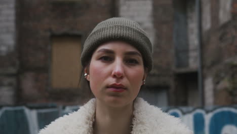 Close-Up-View-Of-A-Young-Girl-Looking-At-Camera-Wearing-A-Beanie-And-Jacket-In-The-Street