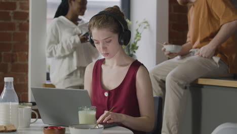 Mädchen-Mit-Kopfhörern,-Die-In-Einer-Wohngemeinschaft-Am-Laptop-Arbeiten
