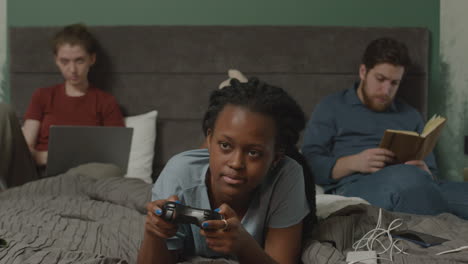 Girl-Playing-Video-Games-On-The-Bed-In-Bedroom