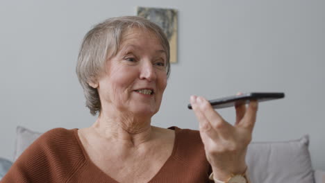 Senior-Woman-Making-Hands-Free-Phone-Call-At-Home