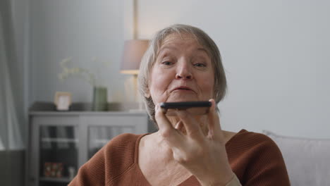 ältere-Frau,-Die-Zu-Hause-Sitzt-Und-Freihändig-Telefoniert