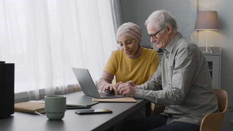 Arabic-Woman-Teaching-An-Elderly-Man-To-Use-A-Laptop-3