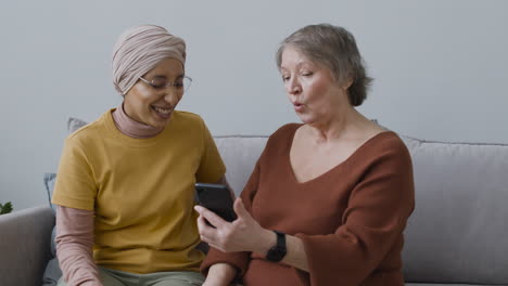 Arabic-Woman-Teaching-An-Elderly-Woman-To-Use-A-Smartphone