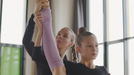 Gymnastic-Blonde-Girl-Rehearsing-A-Ballet-Move-In-Front-Of-Ballet-Barre-1