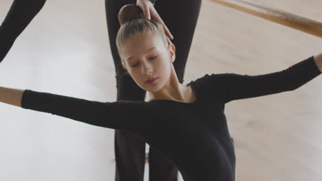 Gymnastic-Blonde-Girl-Rehearsing-A-Ballet-Move-In-Front-Of-Ballet-Barre-3