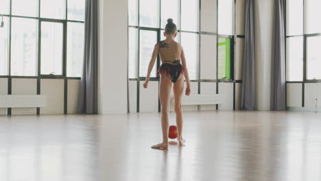 Young-Girl-In-Leotard-Practising-Rhythmic-Gymnastic-With-A-Ball-In-A-Studio