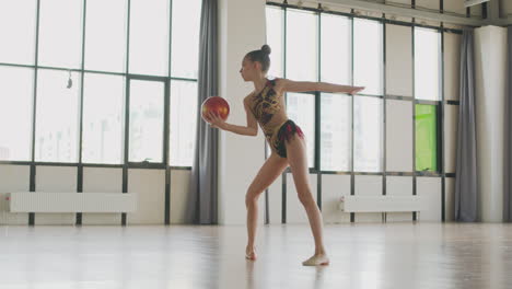 Young-Girl-In-Leotard-Practising-Rhythmic-Gymnastic-With-A-Ball-In-A-Studio-1