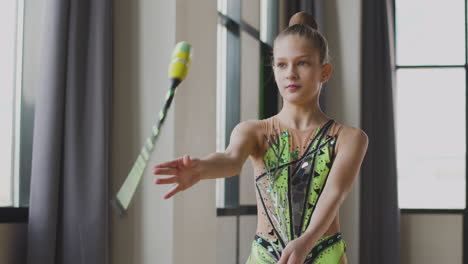 Young-Girl-In-Leotard-Practising-Rhythmic-Gymnastics-With-Clubs-In-A-Studio