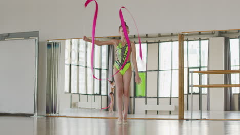 Two-Young-Girls-In-Leotard-Practising-Rhythmic-Gymnastics-With-A-Ribbon-In-A-Studio
