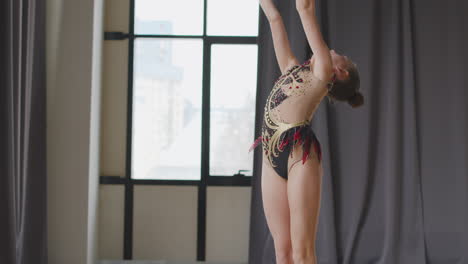 Young-Girl-In-Leotard-Practising-Rhythmic-Gymnastics-With-Clubs-In-A-Studio-4