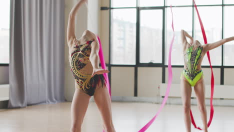 Two-Young-Girls-In-Leotard-Practising-Rhythmic-Gymnastics-With-A-Ribbon-During-A-Rehearsal-In-A-Studio