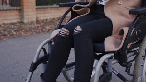 Nicht-Erkennbare-Behinderte-Frau,-Die-Die-Räder-Ihres-Rollstuhls-Für-Eine-Fahrt-Durch-Die-Stadt-Dreht