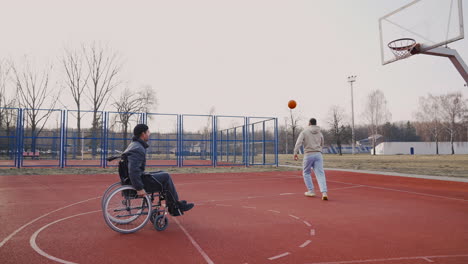 Junger-Behinderter-Mann,-Der-Mit-Seinem-Freund-Basketball-Spielt
