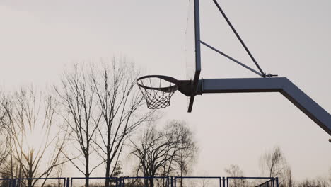 Camera-Focuses-On-Basketball-Hoop-At-Sunset
