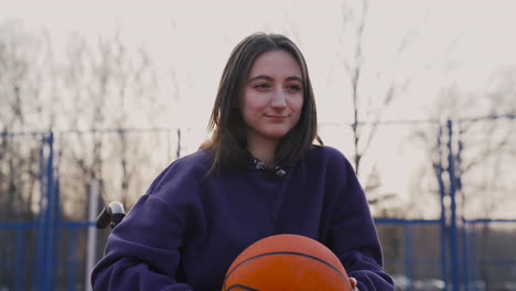 Happy-Disabled-Woman-In-Wheelchair-Looking-At-Camera-While-Holding-A-Basketball-In-Basketball-Court-2