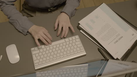 Top-View-Of-Unrecognizable-Female-Employee-Hands-Typing-On-Laptop-Keyboard-At-Workplace