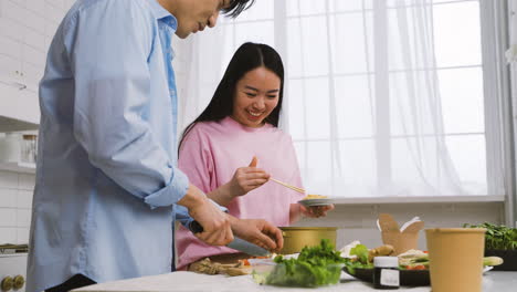 Japanisches-Paar-Kocht-Japanisches-Essen,-Während-Es-In-Der-Küche-Spricht-Und-Lacht