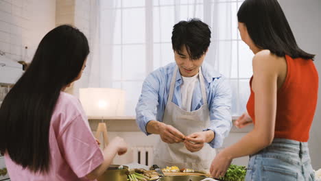 Two-Japanese-Women-And-Man-Are-Cooking-Japanese-Food-While-Talking-In-The-Kitchen