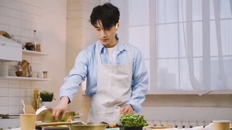 Japanese-Man-Wearing-Appron-And-Cutting-Ingredients-In-The-Kitchen