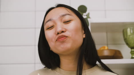 Nahaufnahme-Eines-Glücklichen-Japanischen-Mädchens,-Das-Ramen-Zum-Mitnehmen-In-Der-Küche-Isst