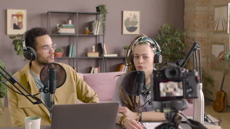 Camera-Is-Recording-A-Woman-And-Man-Sitting-At-Table-While-Doing-A-Podcast-1
