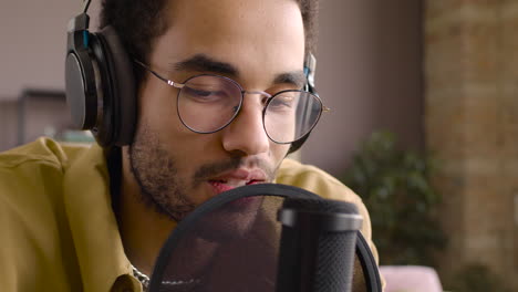 Close-Up-View-Of-Man-Wearing-Glasses-While-He-Is-Talking-Into-A-Microphone-And-Recording-A-Podcast-1