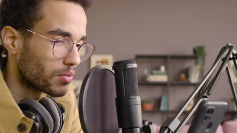 Close-Up-View-Of-Man-Recording-A-Podcast-Wearing-Eyeglasses-And-Headphones
