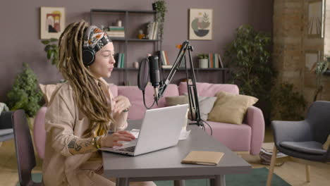 Woman-With-Dreadlocks-Recording-A-Podcast-Wearing-Headphones