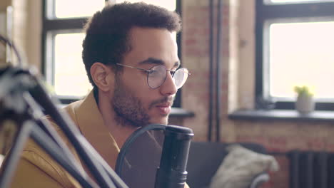 Close-Up-View-Of-Man-With-Eyeglasses-Talking-Into-A-Microphone-Recording-A-Podcast