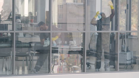 View-From-Outside-Of-And-Arabic-Cleaning-Man-Cleaning-The-Window-Panes-Inside-An-Office