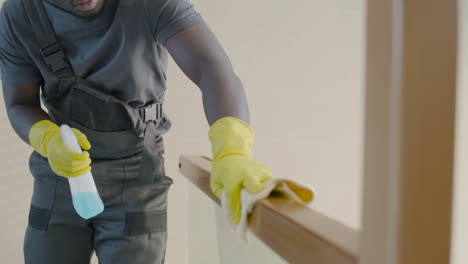 Close-Up-View-Of-Cleaning-Man-Wearing-Gloves-Cleaning-Stair-Railing-Inside-An-Office-Building